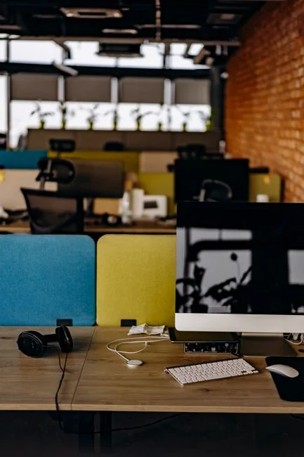 A modern workspace featuring dual computer monitors displaying web design projects, emphasizing technology and productivity.