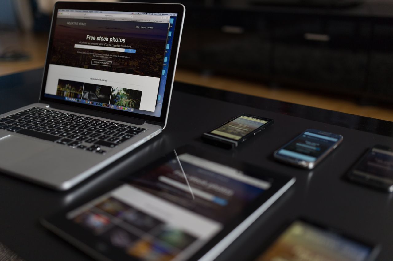Un espace de travail moderne mettant en avant un ordinateur portable, une tablette et des smartphones, parfait pour un usage technologique et indépendant.